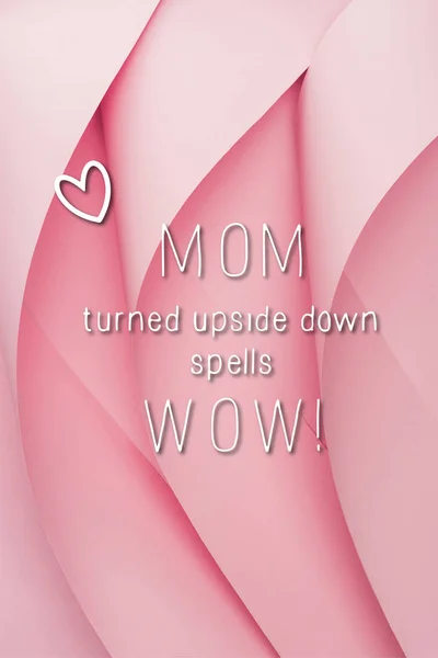 Top view of pink paper swirls with mom wow lettering — Stock Photo