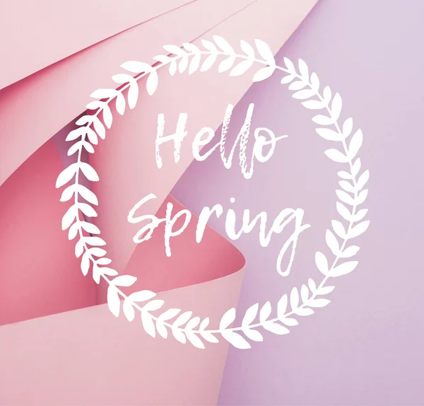 Top view of pink paper swirls on violet background, hello spring illustration — Stock Photo