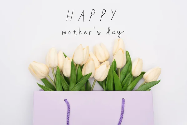 Top view of tulips in violet shopping bag isolated on white, happy mothers day illustration — Stock Photo