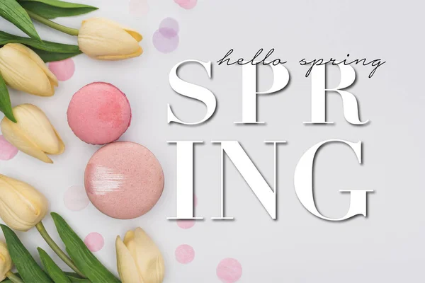 Vista superior de tulipas, macarons rosa e confete violeta isolado no branco, Olá ilustração primavera — Fotografia de Stock