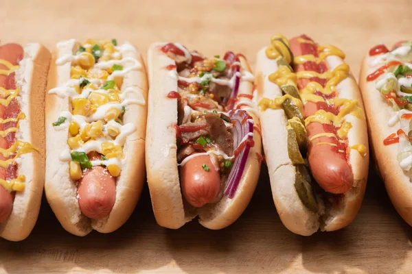 Vista de cerca de perros calientes deliciosos frescos en la mesa de madera - foto de stock