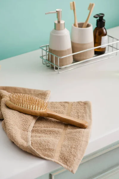 Produtos de higiene na prateleira com escova de cabelo na toalha no banheiro, zero conceito de resíduos — Fotografia de Stock
