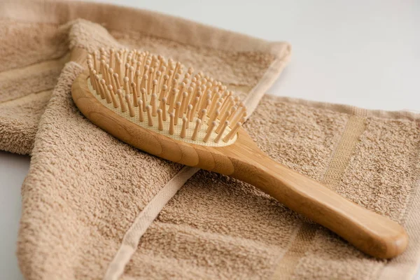 Focus selettivo della spazzola per capelli su asciugamano su sfondo grigio, concetto zero rifiuti — Foto stock