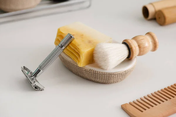 Close up view of dish with soap, shaving brush and razor near comb on grey, zero waste concept — Stock Photo