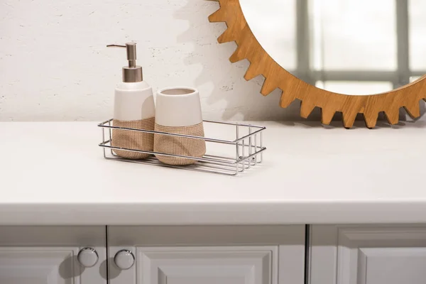 Distributeur savon liquide, porte-brosse à dents sur l'étagère près miroir rond sur le mur dans la salle de bain, concept zéro déchet — Photo de stock