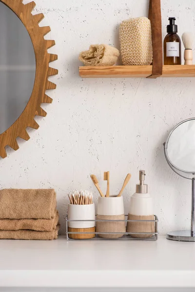 Cuarto de baño con objetos de bambú ecológico y productos cosméticos en los estantes, concepto de cero residuos - foto de stock