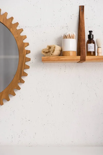 Estante con belleza y productos cosméticos cerca del espejo en el baño, concepto de cero residuos - foto de stock