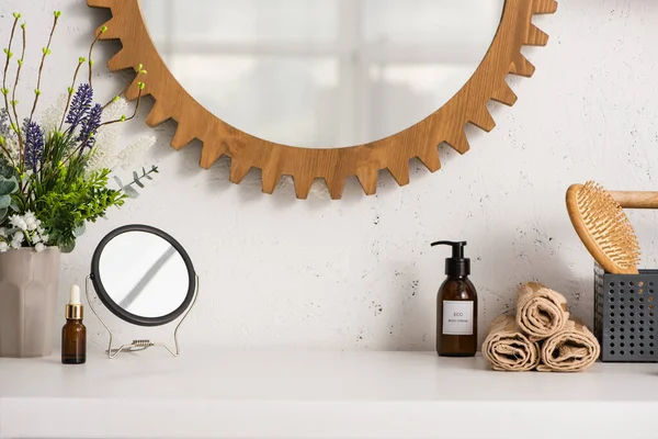 Caja con cepillo de pelo, toallas cerca de productos cosméticos y maceta en el baño, concepto de cero residuos - foto de stock