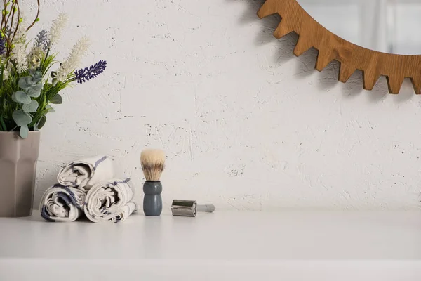 Квітковий горщик, рушники, щітка для гоління та бритва біля дзеркала на стіні у ванній кімнаті, концепція нульових відходів — стокове фото