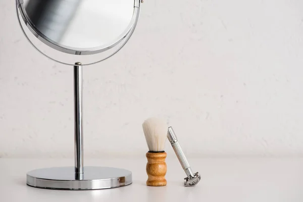 Vue rapprochée du miroir rond, brosse à raser et rasoir sur fond blanc, concept zéro déchet — Photo de stock