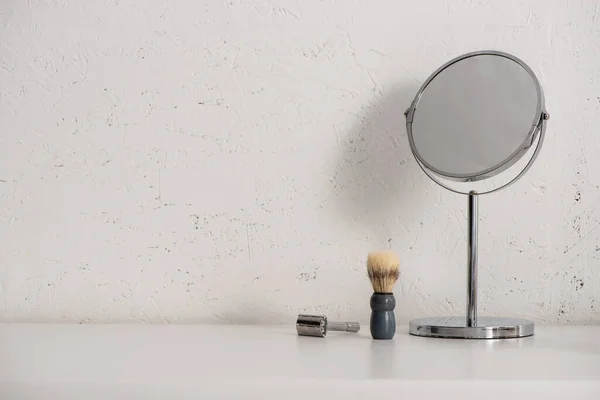 Espelho redondo, escova de barbear e navalha no fundo branco, conceito de desperdício zero — Fotografia de Stock