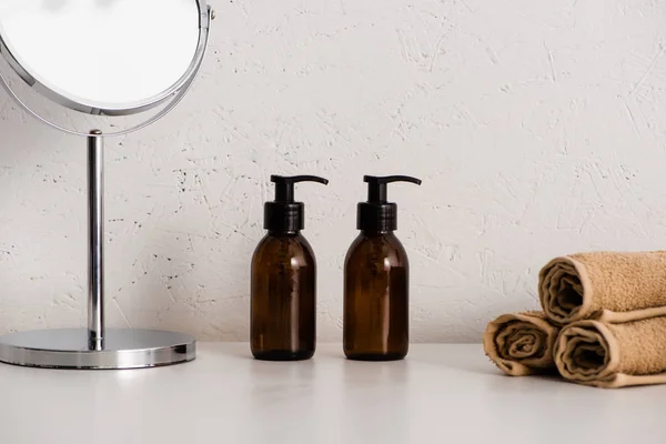Round mirror, dispensers eco body cream and towels on white background, zero waste concept — Stock Photo