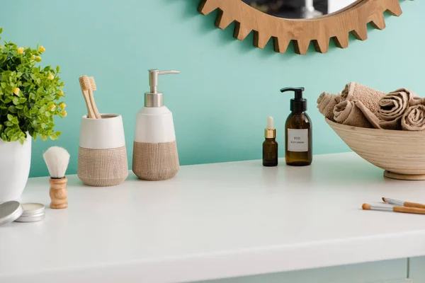 Varios productos de higiene y cosméticos, cuenco con toallas y maceta en el baño, concepto de cero residuos - foto de stock