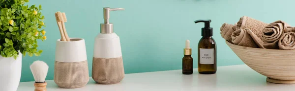 Vista panorámica de maceta, productos cosméticos e higiénicos cerca de cuenco con toallas en el baño, concepto de cero residuos - foto de stock