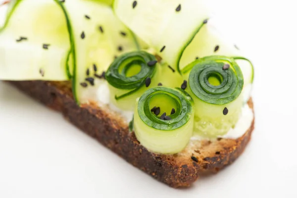 Vista ravvicinata del pane tostato fresco al cetriolo con semi su sfondo bianco — Foto stock