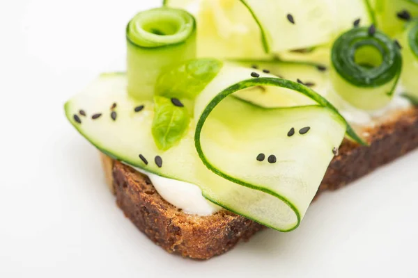Закрыть вид на свежий огуречный тост с семенами на белом фоне — стоковое фото