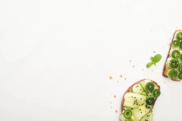 Top view of fresh cucumber toasts with seeds, mint on white background — Stock Photo