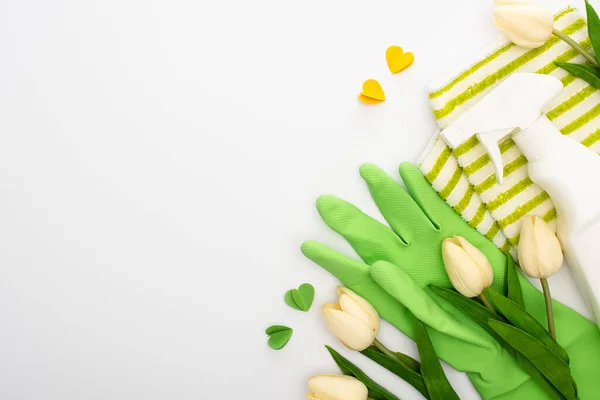 Vista superior de tulipas de primavera e suprimentos de limpeza verde e corações no fundo branco — Fotografia de Stock