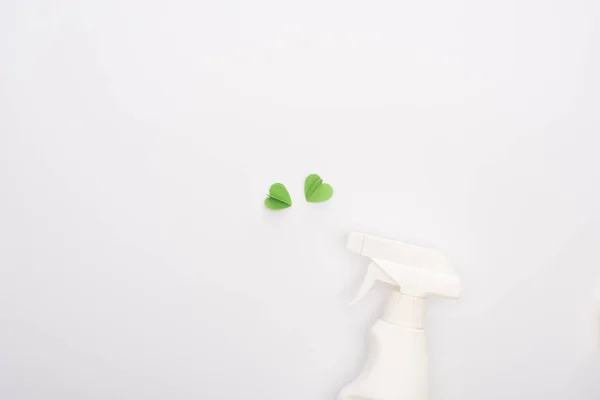Vista dall'alto di cuori verdi e bottiglia spray su sfondo bianco — Foto stock