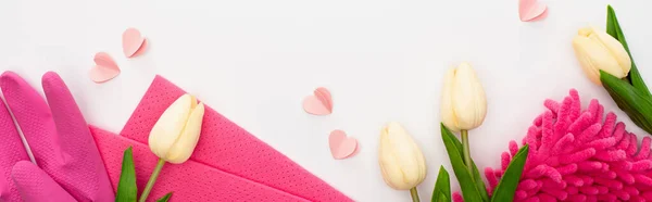 Вид зверху весняних тюльпанів і приладдя для прибирання рожевого кольору на білому тлі, панорамний знімок — стокове фото