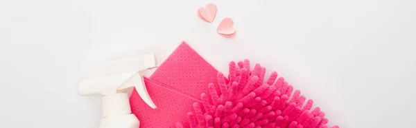 Vista dall'alto di prodotti per la pulizia rosa e cuori su sfondo bianco, scatto panoramico — Foto stock