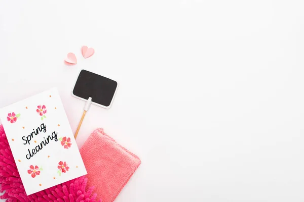 Top view of pink cleaning supplies, hearts and empty sign near spring cleaning card on white background — Stock Photo