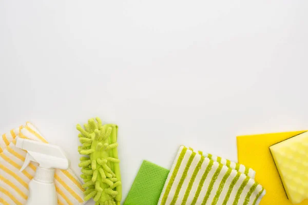 Top view of green and yellow cleaning supplies on white background — Stock Photo