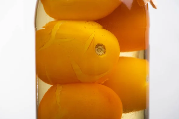 Close up view of homemade tasty canned yellow tomatoes in jar isolated on white — Stock Photo