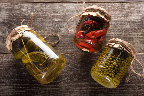 Top view of homemade tasty pickles in jars on wooden table — Stock Photo