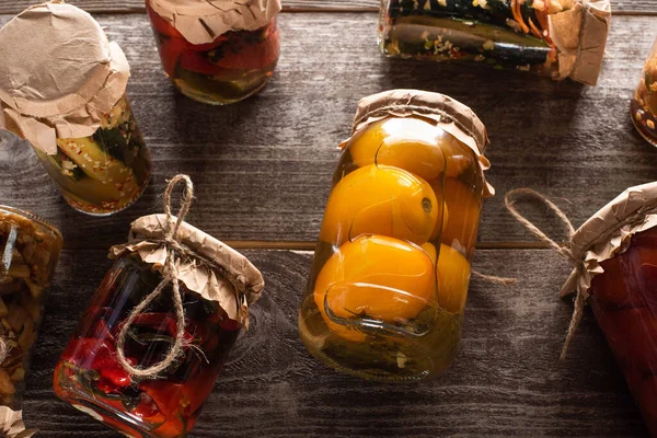 Top view of homemade tasty pickles in jars on wooden table — Stock Photo