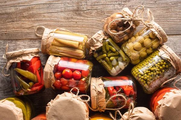 Top view of tasty homemade pickles in jars on wooden rustic table — Stock Photo