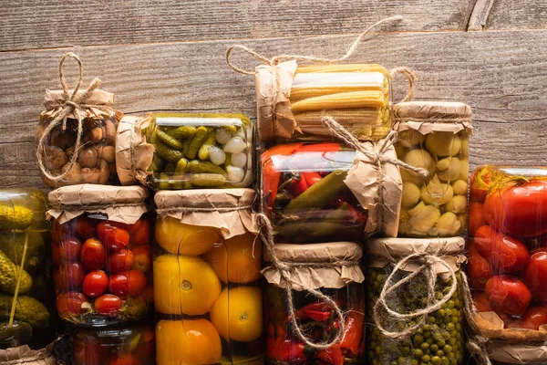 Top view of tasty homemade pickles in jars on wooden rustic table — Stock Photo