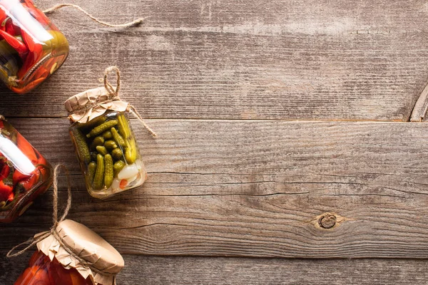 Ansicht von hausgemachten leckeren Essiggurken in Gläsern auf Holztisch mit Kopierraum — Stockfoto