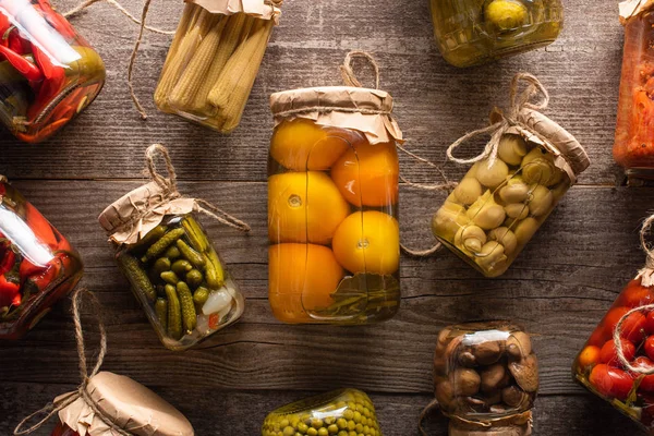 Vista dall'alto di deliziosi sottaceti gustosi fatti in casa su tavolo rustico in legno — Foto stock