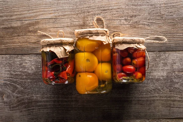 Blick von oben auf köstliche hausgemachte leckere Essiggurken auf rustikalem Holztisch — Stockfoto