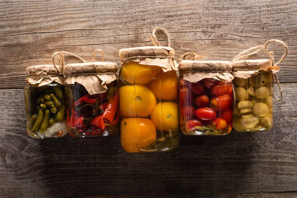 Blick von oben auf köstliche hausgemachte leckere Essiggurken auf rustikalem Holztisch — Stockfoto