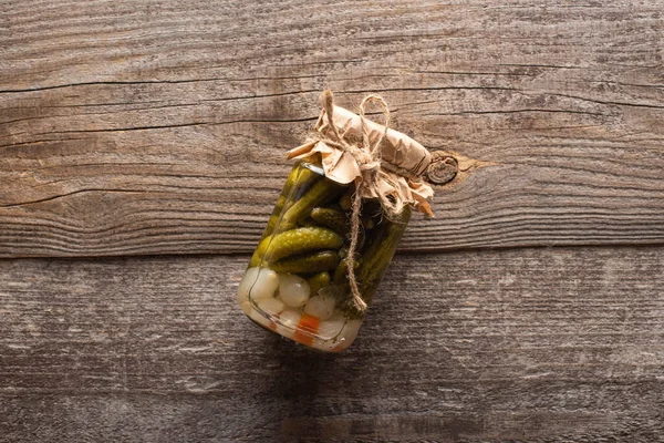 Vista dall'alto di gustosi cetrioli in scatola fatti in casa in vaso su tavolo di legno — Foto stock
