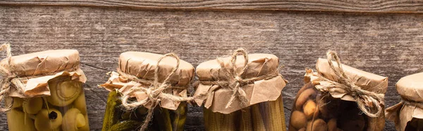 Top view of homemade pickles in jars on wooden table with copy space, panoramic shot — Stock Photo