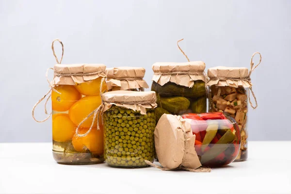 Picles deliciosos caseiros em frascos isolados em cinza — Fotografia de Stock