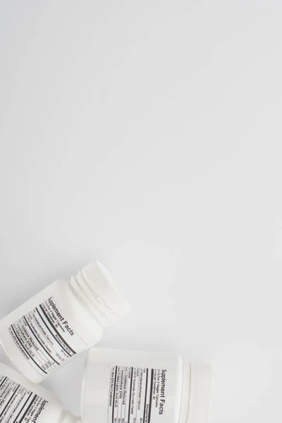 Vista superior de recipientes com suplementos dietéticos sobre fundo branco — Fotografia de Stock