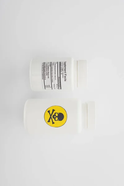 Vista superior de recipientes com suplementos dietéticos e veneno sobre fundo branco — Fotografia de Stock
