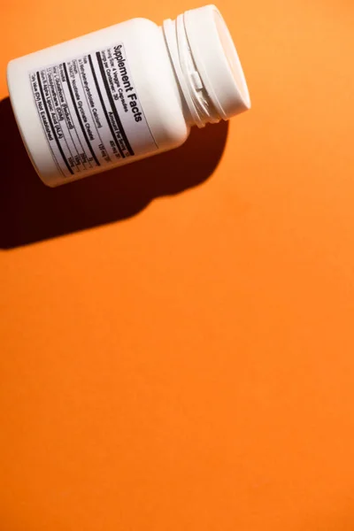 Vista de alto ângulo do recipiente branco no fundo laranja — Fotografia de Stock