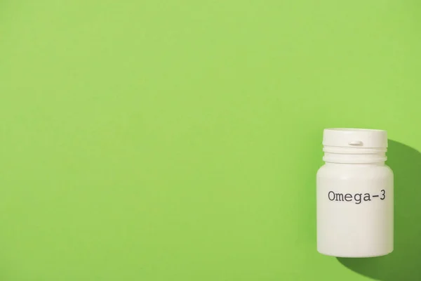 Top view of container with omega-3 lettering on green background — Stock Photo