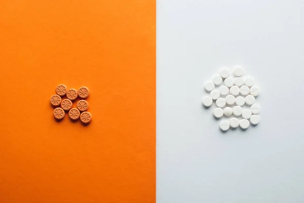 Vue du dessus des médicaments sur fond blanc et orange — Photo de stock