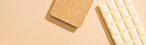 Vista superior de deliciosas barras de chocolate branco no fundo bege, tiro panorâmico — Fotografia de Stock