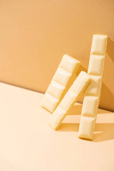 Dolce delizioso rotto cioccolato bianco bar su sfondo beige — Foto stock