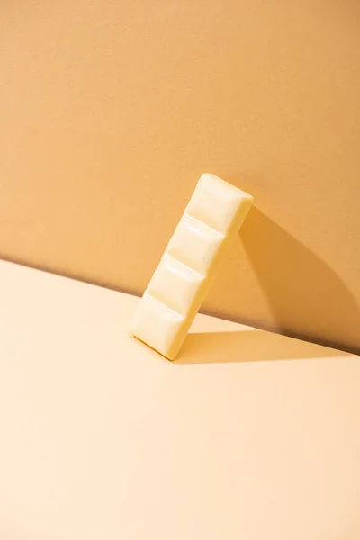 Солодкий смачний зламаний білий шоколадний шматок на бежевому фоні — стокове фото