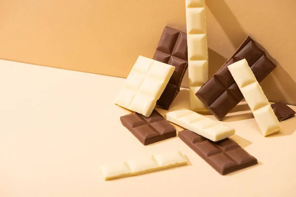 Délicieux sucré noir, lait et chocolat blanc sur fond beige — Photo de stock