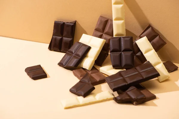Dolce delizioso cioccolato fondente, al latte e bianco su sfondo beige — Foto stock