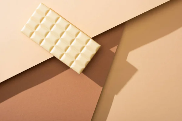 Vista superior de deliciosa barra de chocolate branco inteiro no fundo bege — Fotografia de Stock